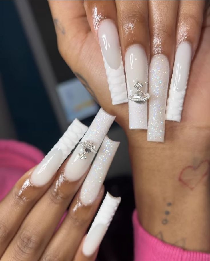 Sophisticated Long White Nail Design with Minimal Rhinestones and Glitter Overlay.