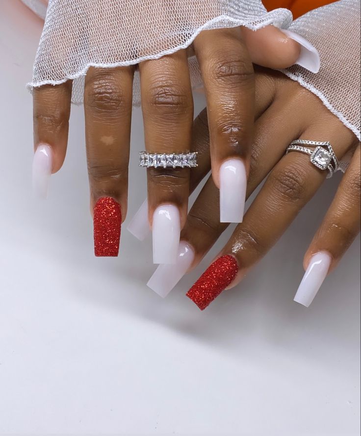 Sophisticated Nail Design: Elegant Glossy White Tips with Vibrant Red Glitter Accents