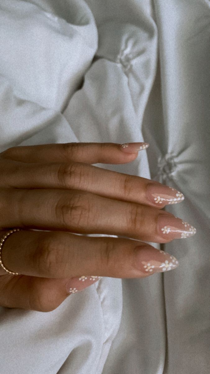 Chic Nude Nail Design with Delicate Floral Accents for Effortless Elegance.