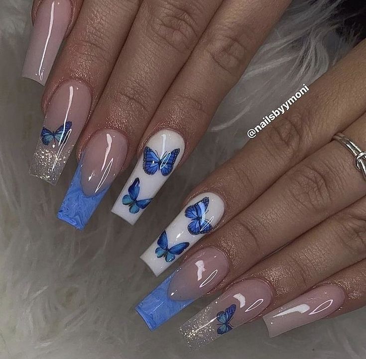 Chic Nail Design: Delicate Blue Butterfly Motifs with Sparkling Accents in Nude and Pastel Tones.