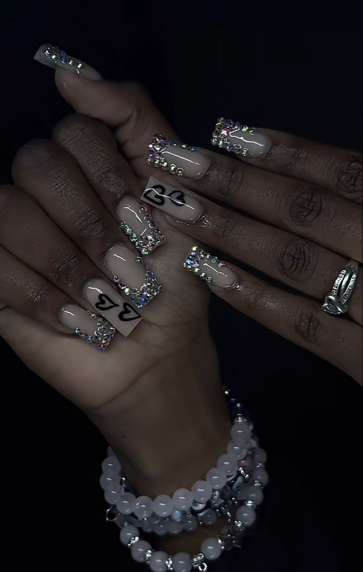 Chic Nude Nail Design with Rhinestone Tips and Playful Heart Motifs