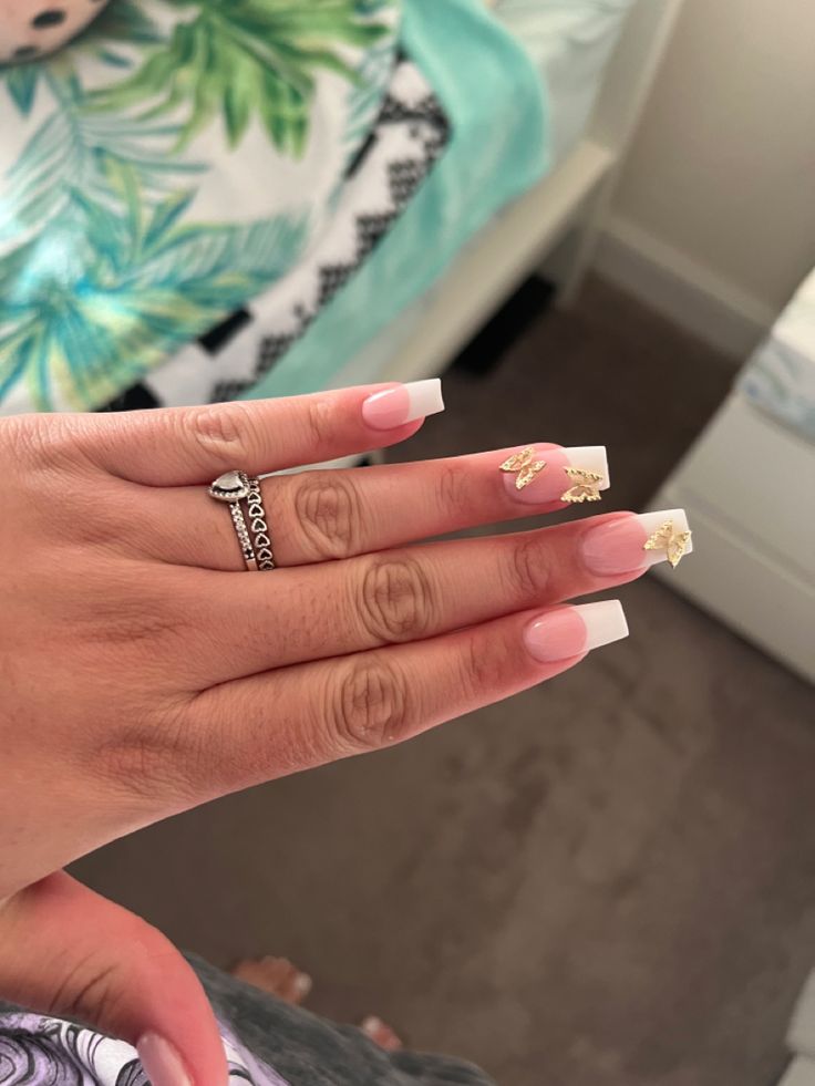 Sophisticated French Manicure with Soft Pink Tips and Gold Leaf Accents