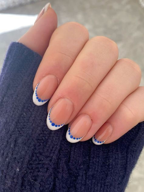 Sophisticated French Manicure with Intricate Blue Dots on a Nude Base.