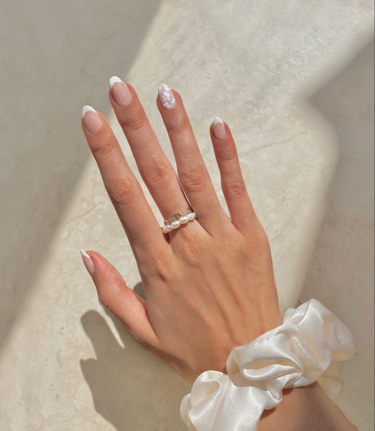 Chic French Manicure with Textured Pearls and Satin Scrunchie Accent.