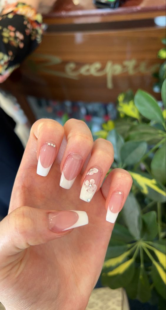 Elegant French Manicure with Floral Accents and Gems