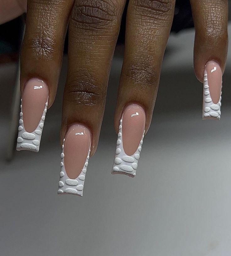 Modern French Tip Nail Design with Textured White Dots on Nude Base.