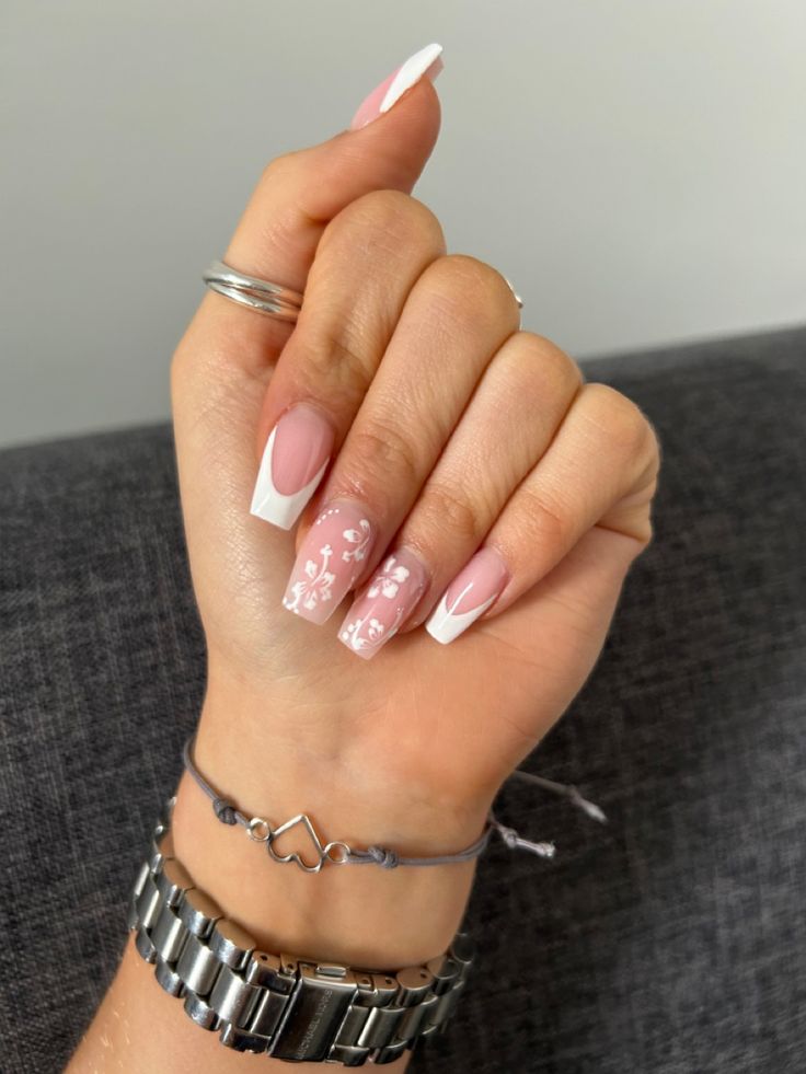 Elegant Nail Design: Classic French Tips with Soft Pink and Floral Accents.