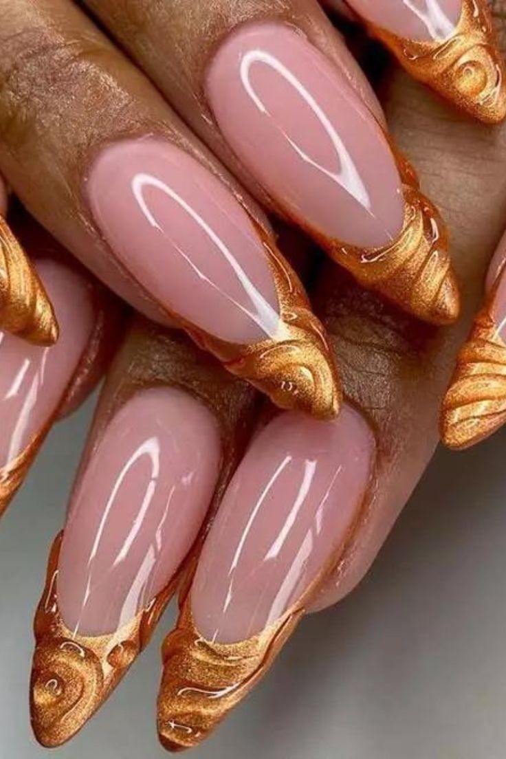 Elegant Almond-Shaped Nail Design with Gold Accents on Glossy Nude Base.