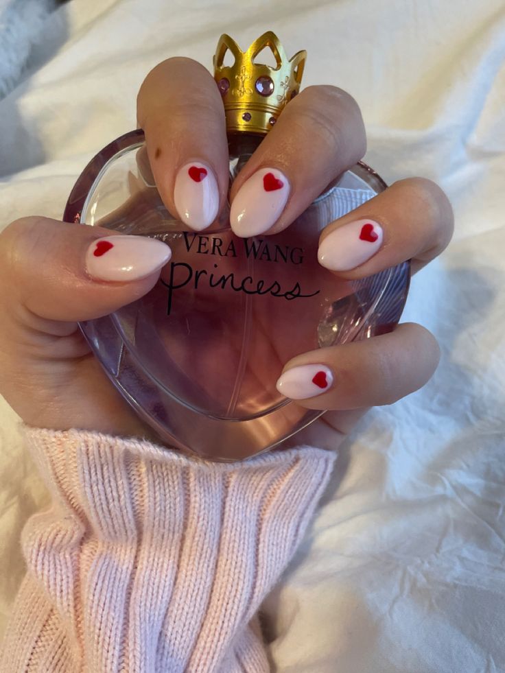 Romantic Nail Design with Nude Base and Whimsical Red Heart Accents.