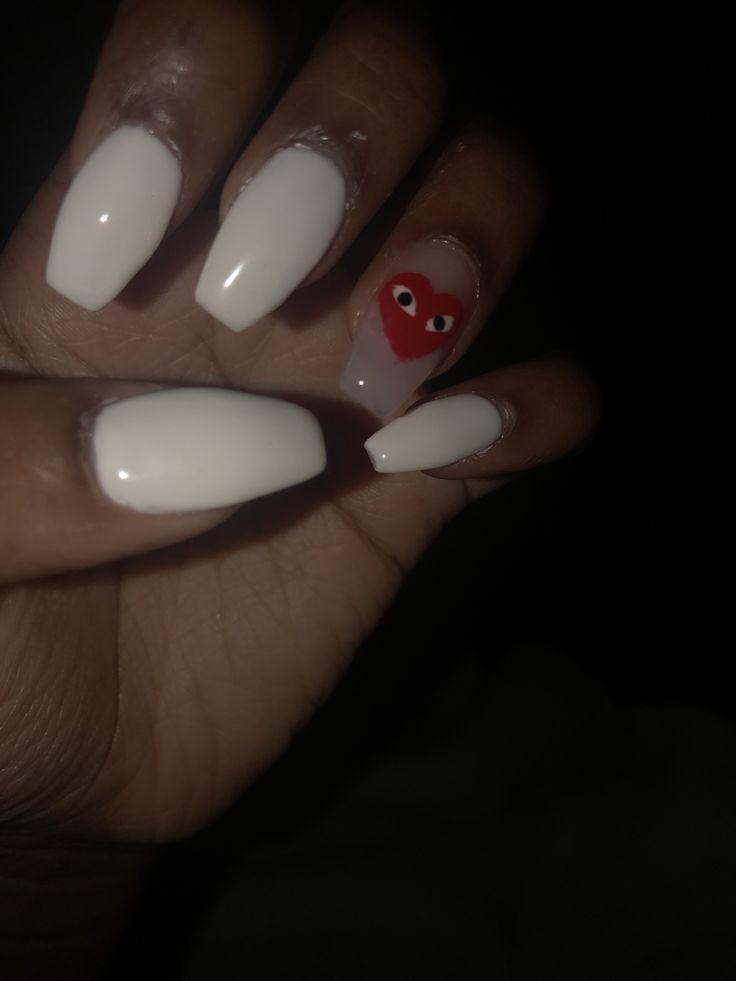 Chic White Nails with Whimsical Red Heart Accent: A Trendy Blend of Simplicity and Fun.