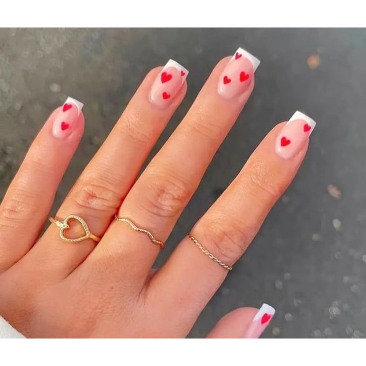 Elegant French Manicure with Playful Red Heart Accents.