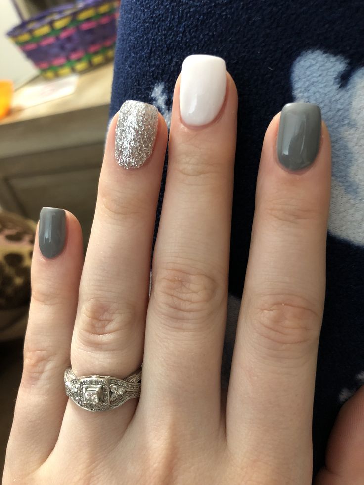 Chic Nail Design: Elegant Grey and Glossy White with Shimmering Silver Accent.