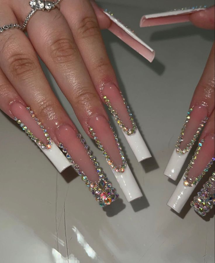 Elegant Stiletto Nail Design with Vibrant Rhinestones and Striking Contrast.