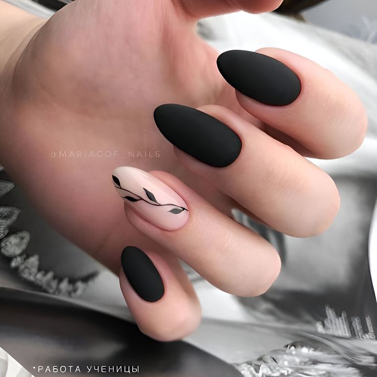 Sophisticated Matte Black and Nude Nail Design with Delicate Leaf Pattern