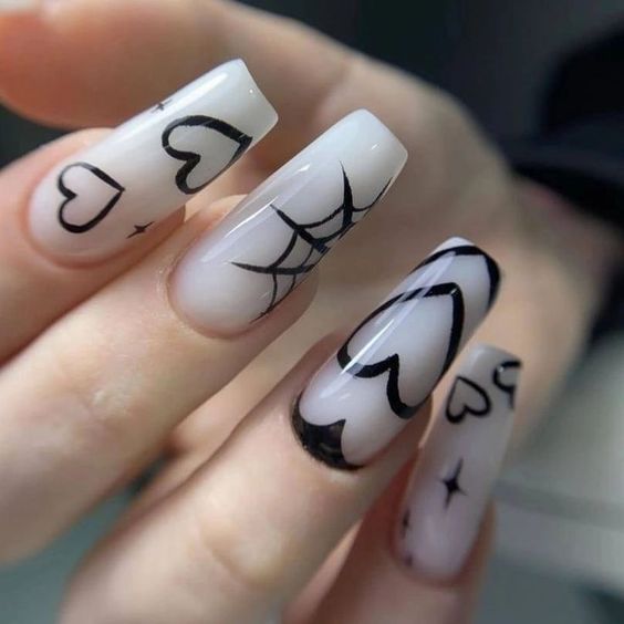 Playful yet Edgy Nail Design: Black Hearts and Spiderwebs on Sheer Canvas