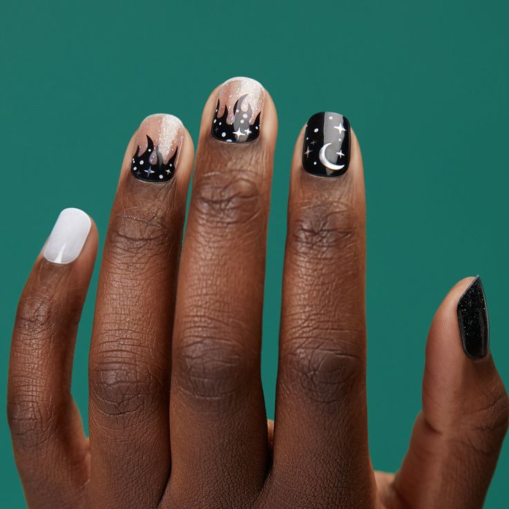 Edgy Artistic Nail Design with Black, White, and Nude Shades Featuring Vivid Flame Patterns and Celestial Motifs.