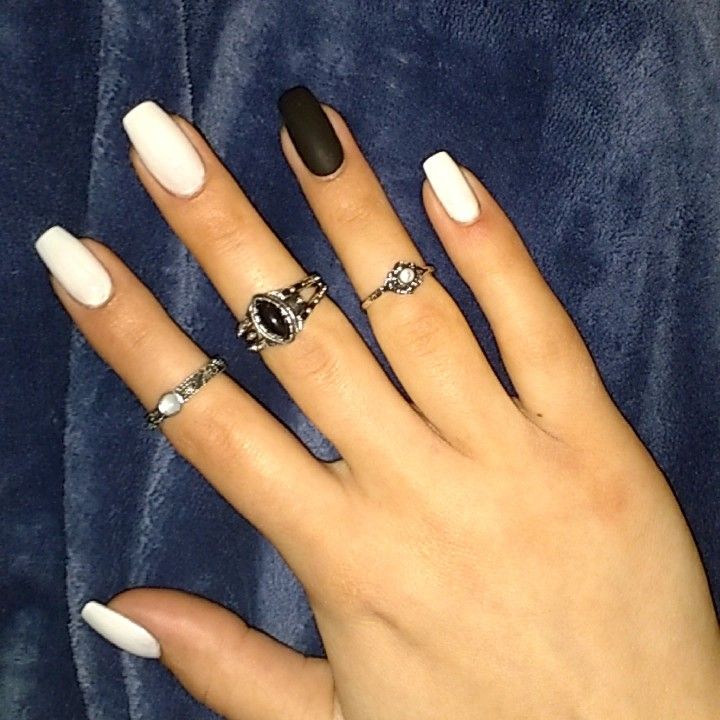 Elegant Almond-Shaped Nail Design in Matte Black and Glossy White with Chic Silver Accents.