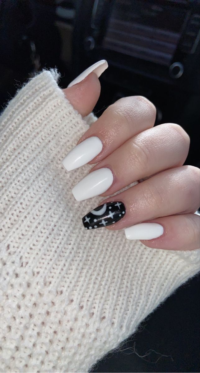 Celestial-Themed Nail Art: Glossy White Tips with Intricate Black and White Accent Design.