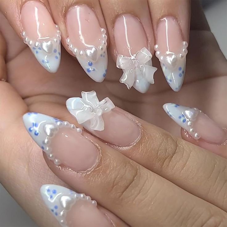 Sophisticated Stiletto Nail Design with Delicate Bows, Pearls, and Pastel Floral Accents.