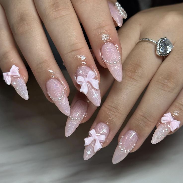 Chic Soft Pink Nail Design with Bows and Sparkling Accents for Any Occasion.