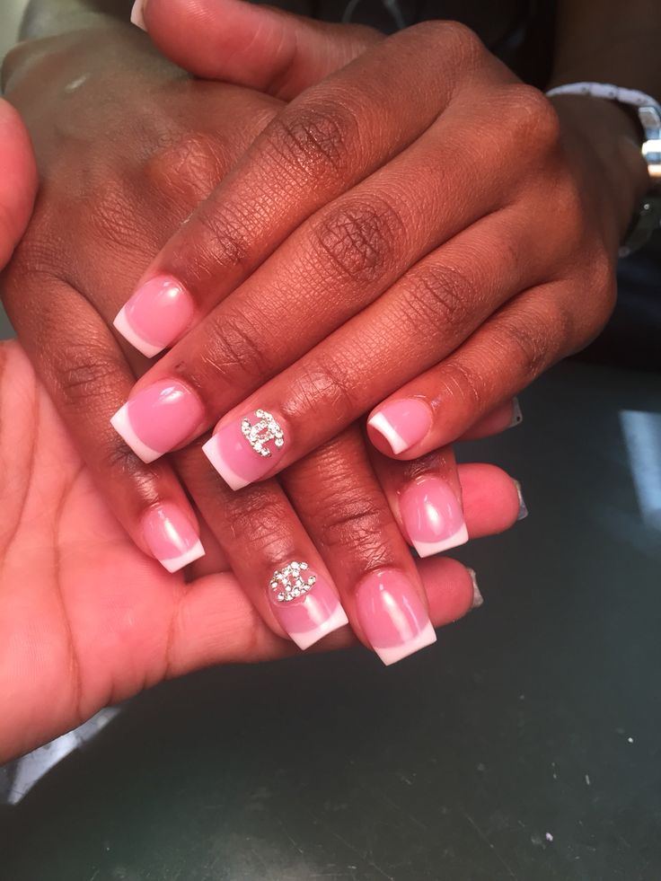 Chic French Tip Manicure with Soft Pink Base and Rhinestone Accent.