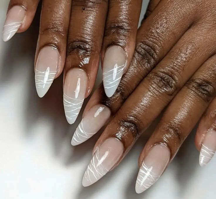 Chic Almond-Shaped Nails: Nude Base with Artistic White Tips and Intricate Designs