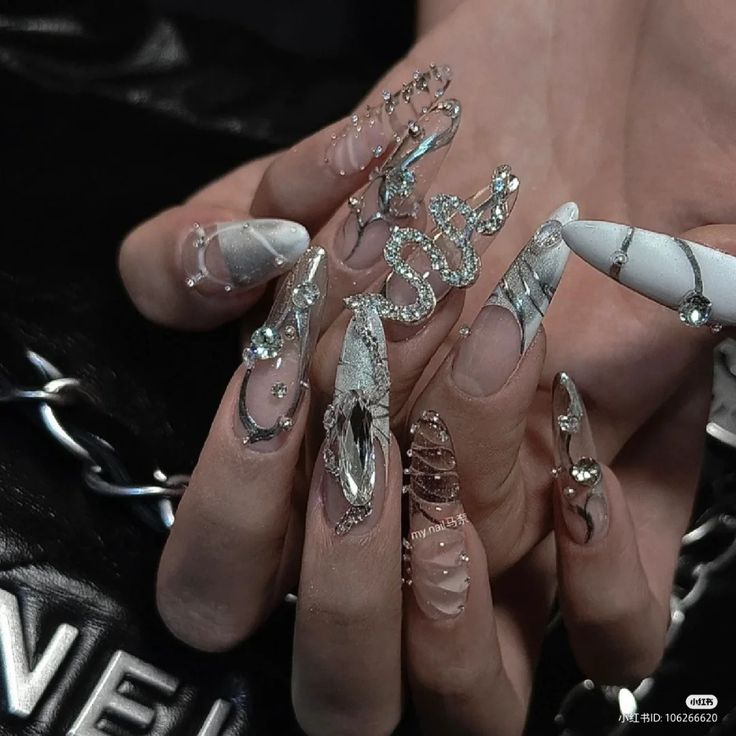 Glamorous Intricate Nail Design with Elongated Tips and Textured Metallic Accents.