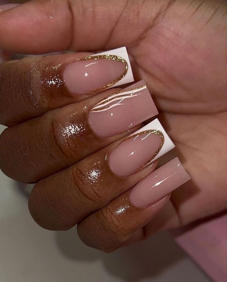 Sophisticated Nude and White Nail Design with Glamorous Gold Accents.