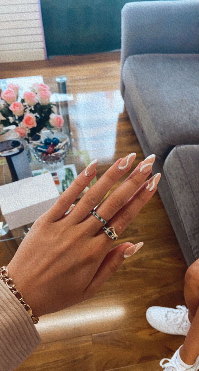 Chic Almond-Shaped Nails with Subtle French Tips and Stylish Rings.