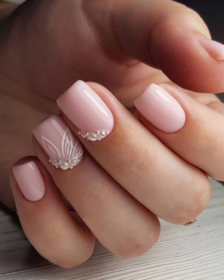 Sophisticated Soft Pink Nail Design with Delicate Floral Patterns and Pearl Accents.