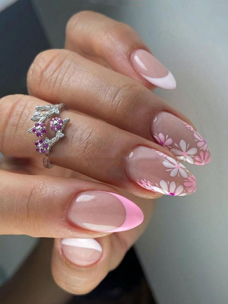 Chic Light Pink French Tip Nails with Delicate Floral Accents and Stylish Ring.