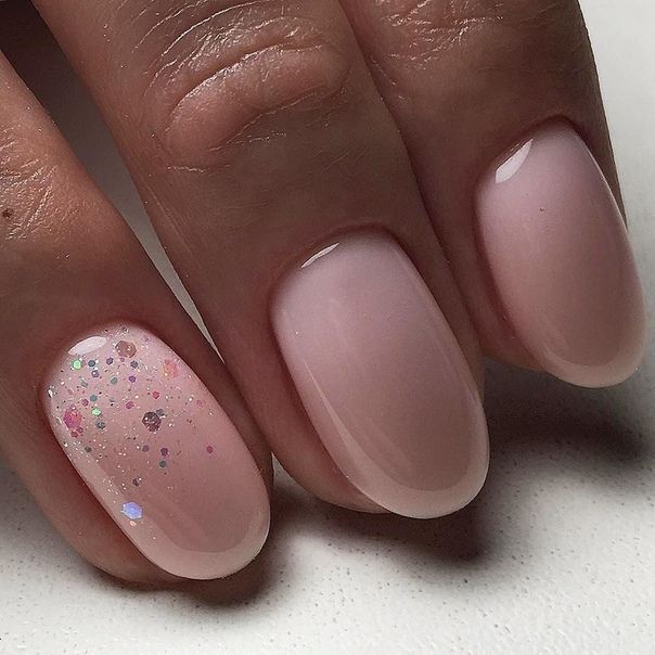 Sophisticated Nude Pink Nail Design with Pastel Glitter Accent.