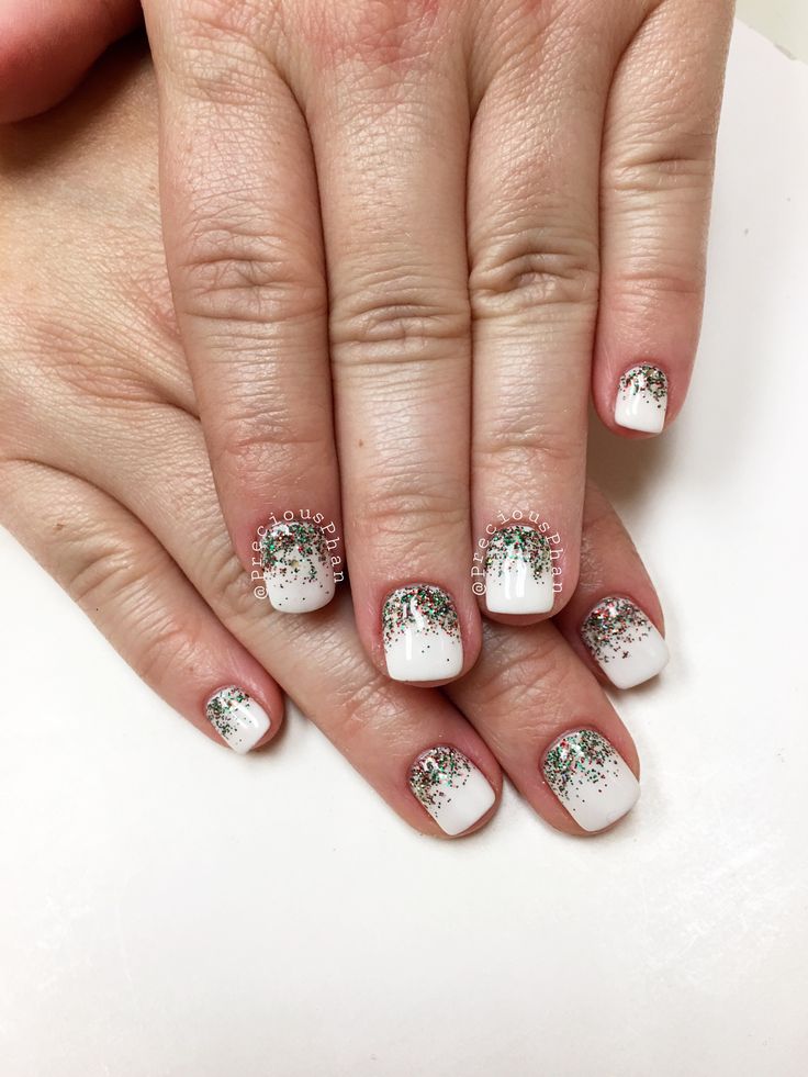 Festive Holiday Nail Design: Elegant White Base with Shimmering Green and Silver Glitter Gradients.