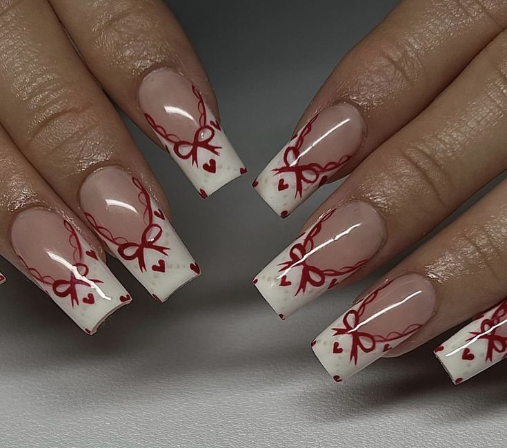 Nude and White Chic Nail Design with Intricate Red Bows and Hearts