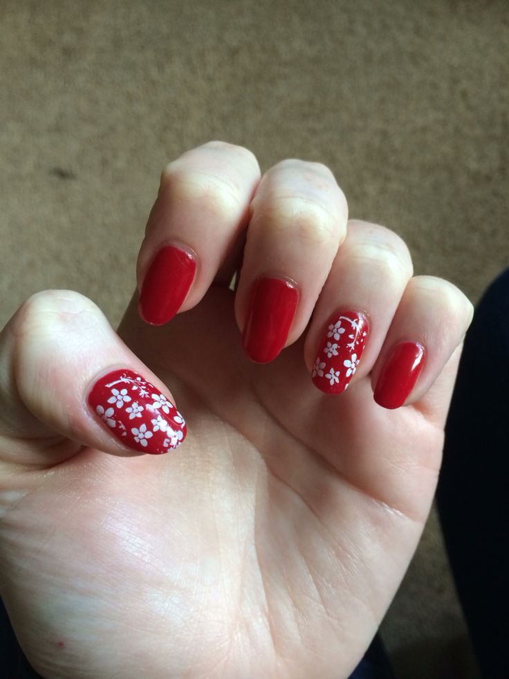 Charming Glossy Red Nail Design with Floral Accents for a Stylish Look.