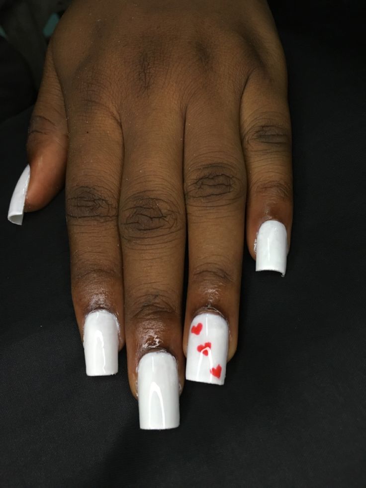 Elegant White Acrylic Nails with Playful Red Heart Accent for a Fresh Look.