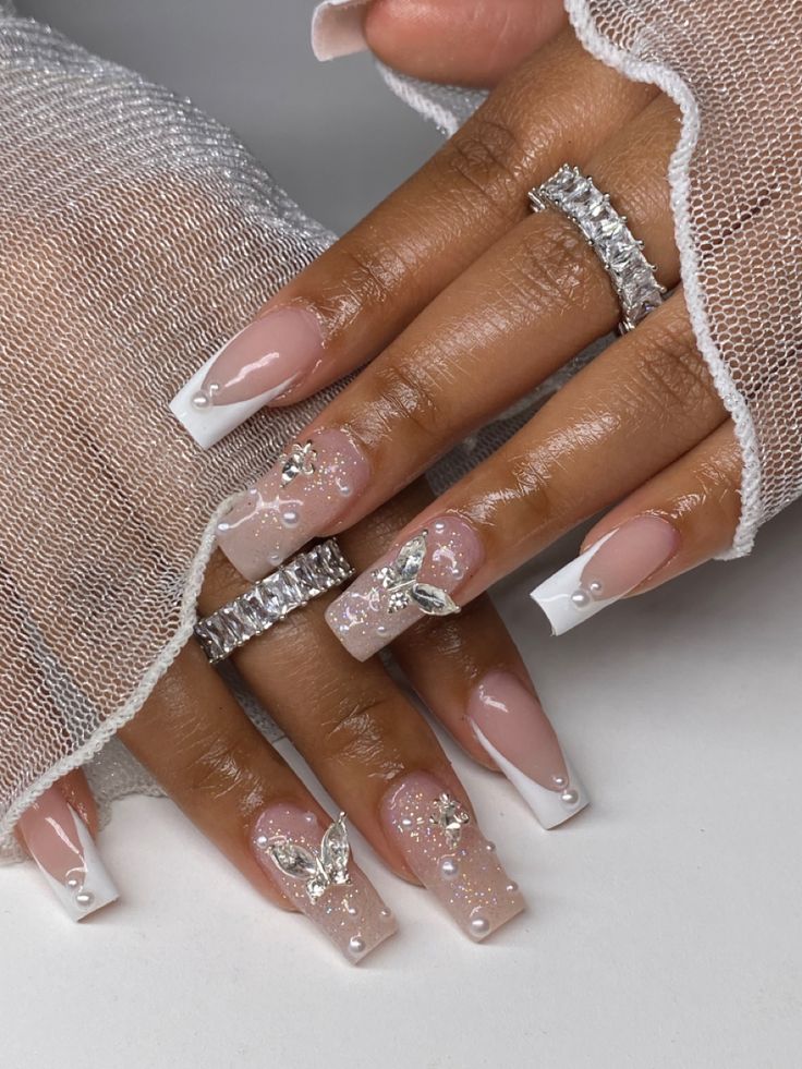 Glamorous Elegant Nail Design: Classic French Tips with Soft Pink Shades and Floral Accents.