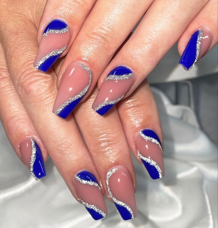 Elegant Striking Nail Design: Vibrant Blue and Nude Tones with Glamorous Silver Detailing