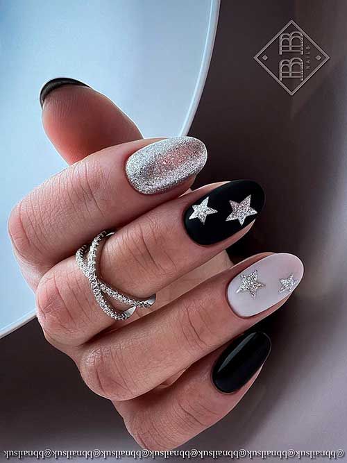 Celestial Chic: Sleek Black and Pastel Nail Design with Glitter and Star Accents.