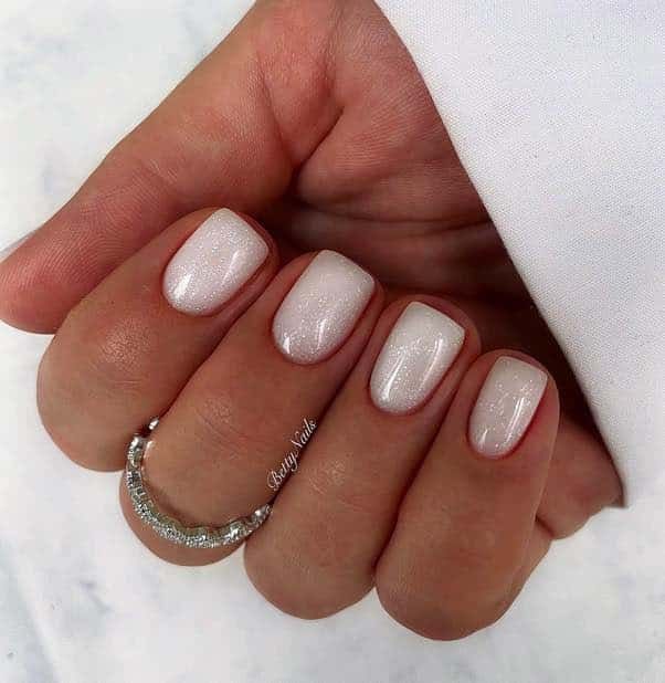 Sophisticated Pearlescent White Nail Design with Delicate Accent.