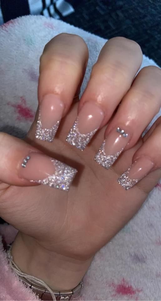 Elegant Nude and Glitter Gradient Nail Design with Rhinestones for Special Occasions.