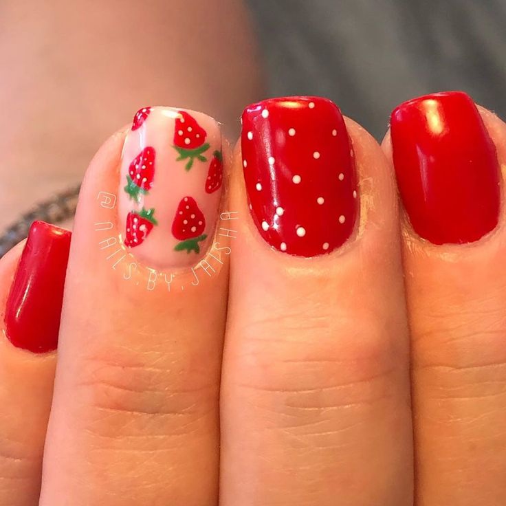 Cheerful Vibrant Red Nail Design with Playful Strawberry Patterns and Polka Dots.