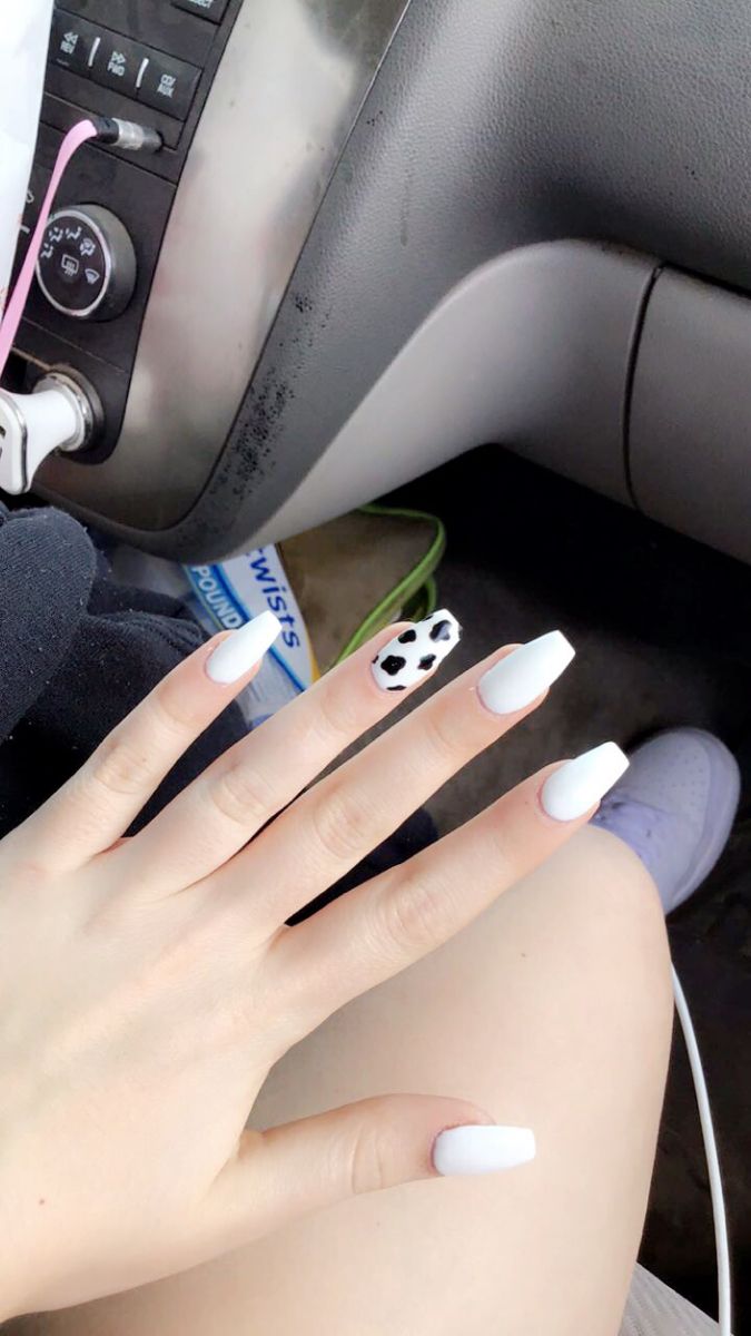 Chic White Acrylic Nails with Playful Cow Print Accent for a Stylish Look.