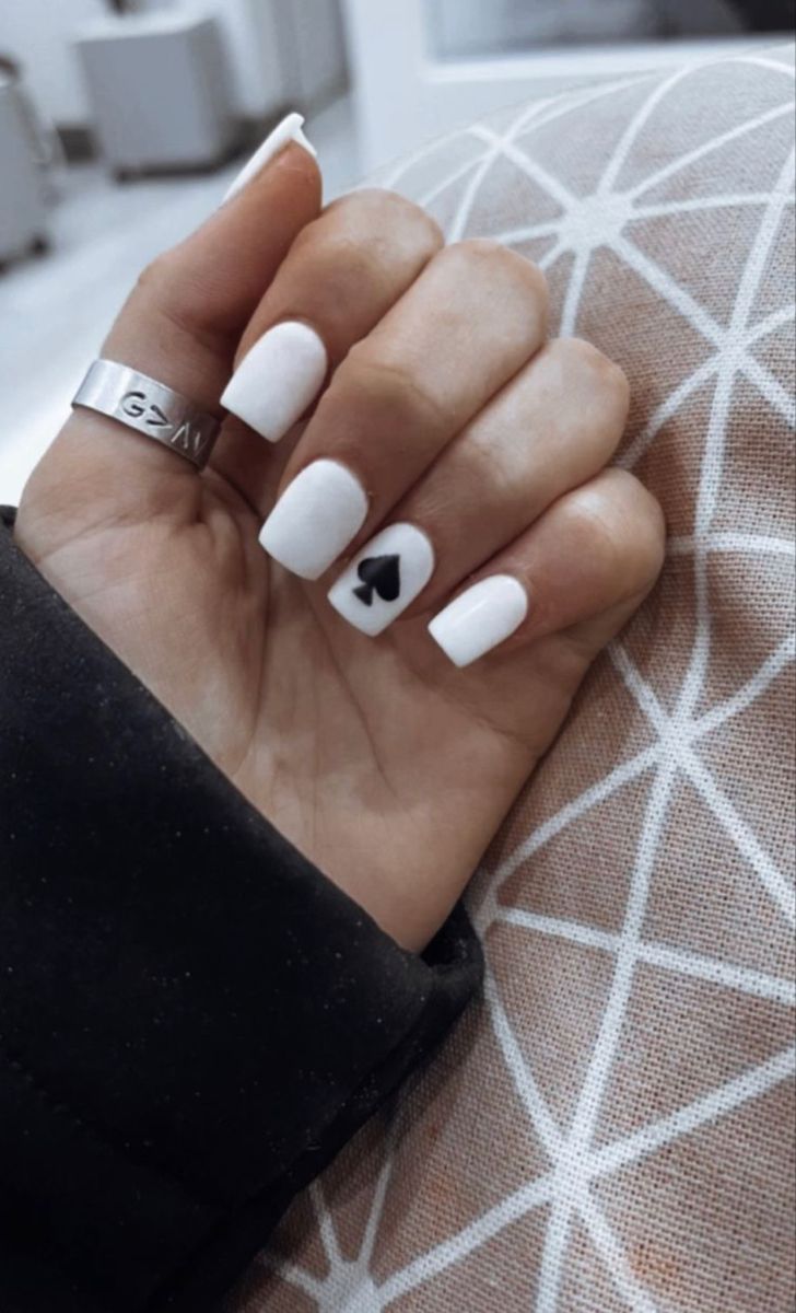 Chic Elegant White Nails with Playful Black Spade Accent: A Modern Minimalist Design for Any Occasion.