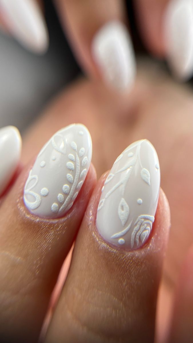 Chic Elegant White Nails with Intricate Floral and Swirling Designs for Special Occasions.