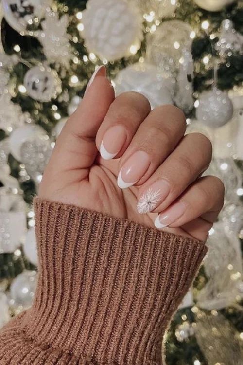 Elegant Winter Nail Design: Soft Nude Base with Classic White Tips and Festive Snowflake Accent.