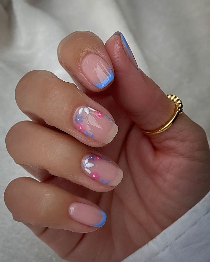 Whimsical Elegance: Soft Pink Nails with Delicate Blue Tips and Playful Accents.