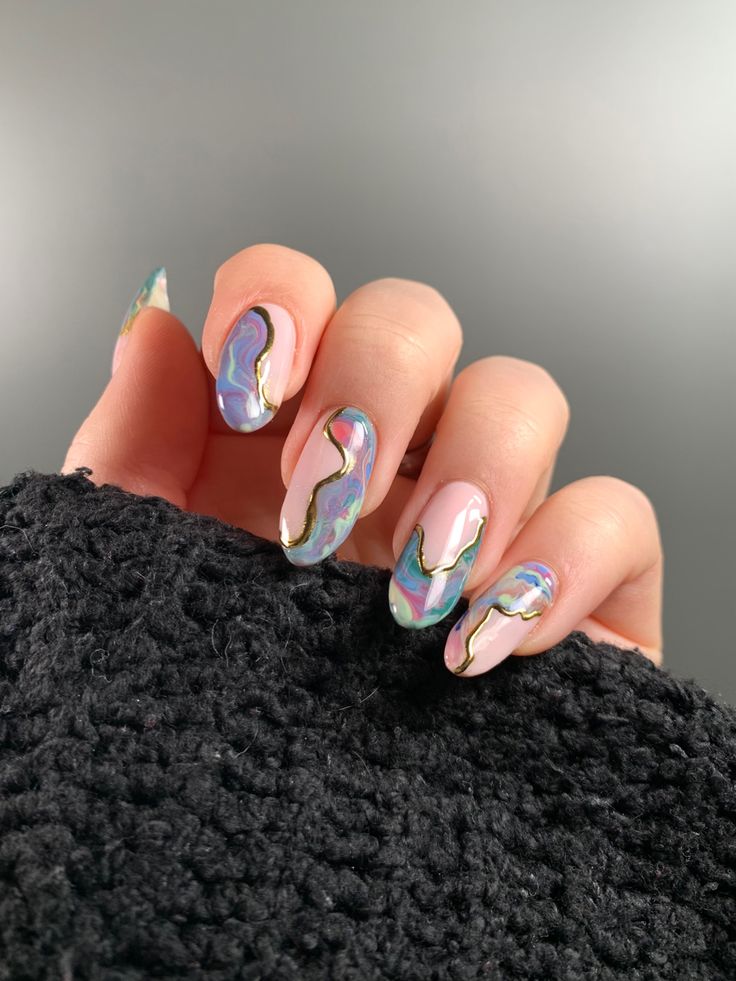 Mesmerizing Colorful Nail Design with Soft Pink, Iridescent Swirls, and Metallic Gold Accents