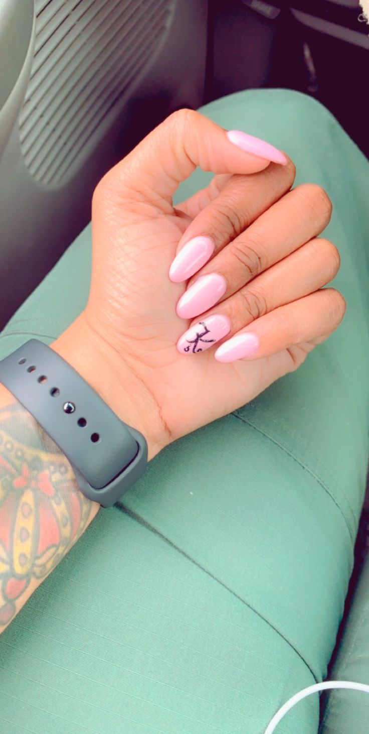 Elegant Almond-Shaped Nails with Soft Pink Polish and Unique Design Compliment Casual Style.