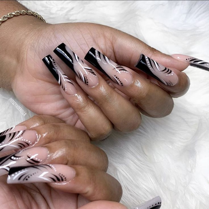 Sophisticated Elegant Long Acrylic Nails with Nude and High-Gloss Black Finish and Artistic White Swirl Patterns.